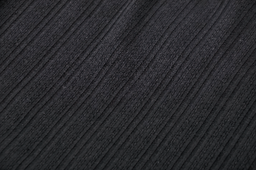 Close-up of elegant black ribbed fabric, perfect for a gothic lace camisole top.