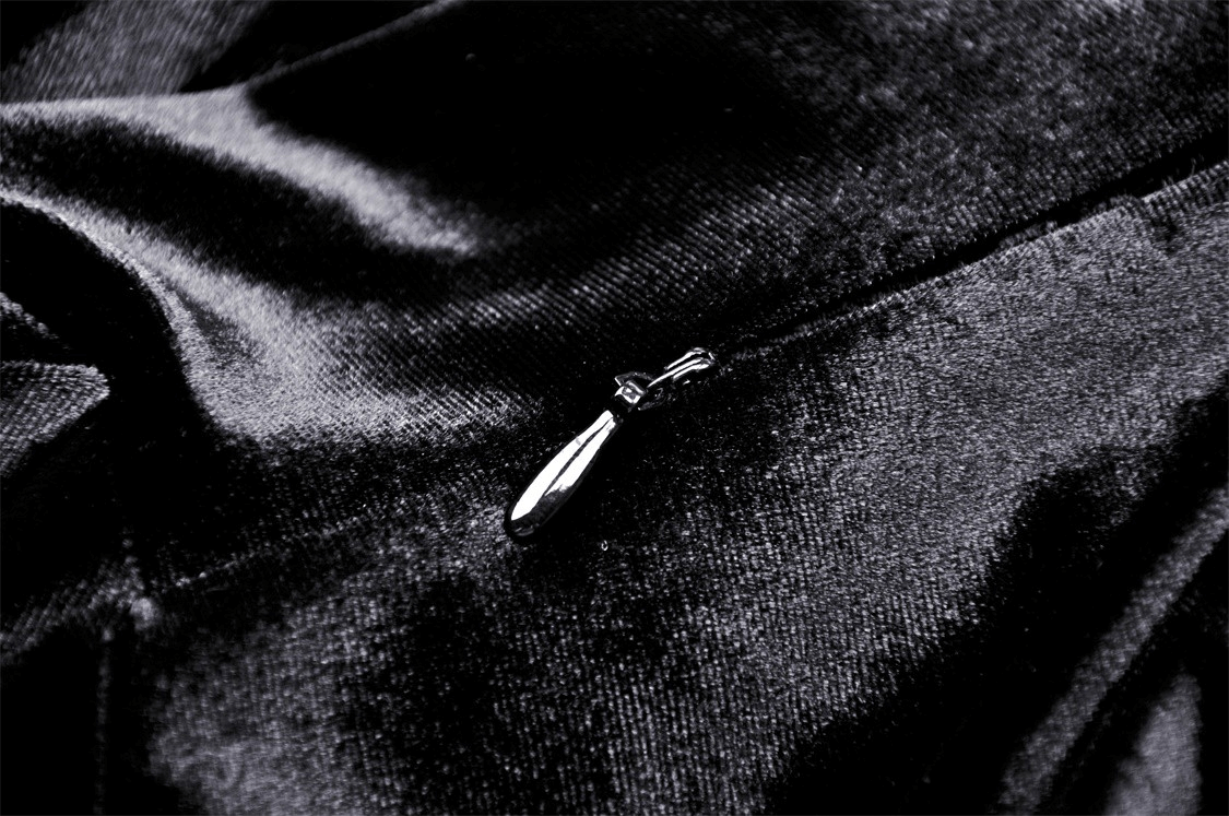 Close-up of a sleek black zipper on luxurious fabric, adding detail to an elegant Victorian gown.