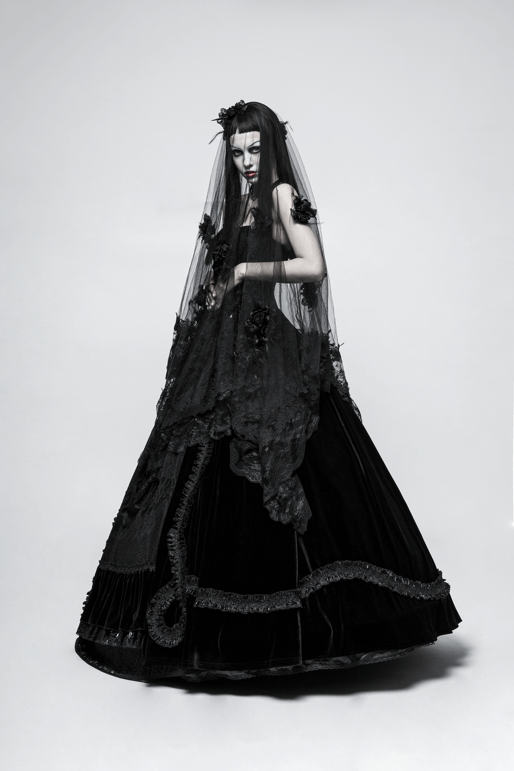 Elegant black lace wedding veil with 3D roses, modeled by a bride in a dark gown, capturing gothic romance.