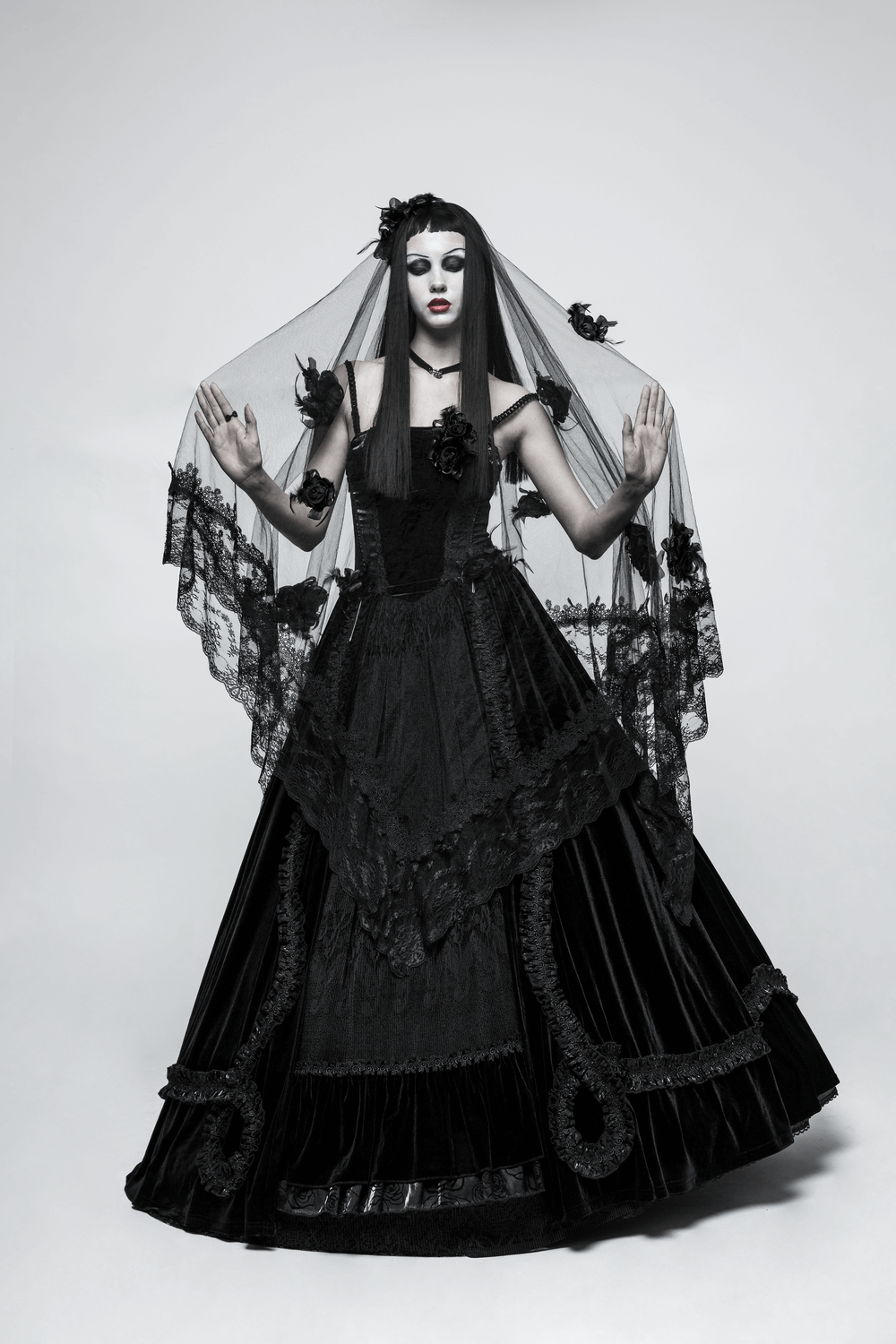 Elegant black lace wedding veil with 3D roses worn by model in dramatic gothic bridal attire.
