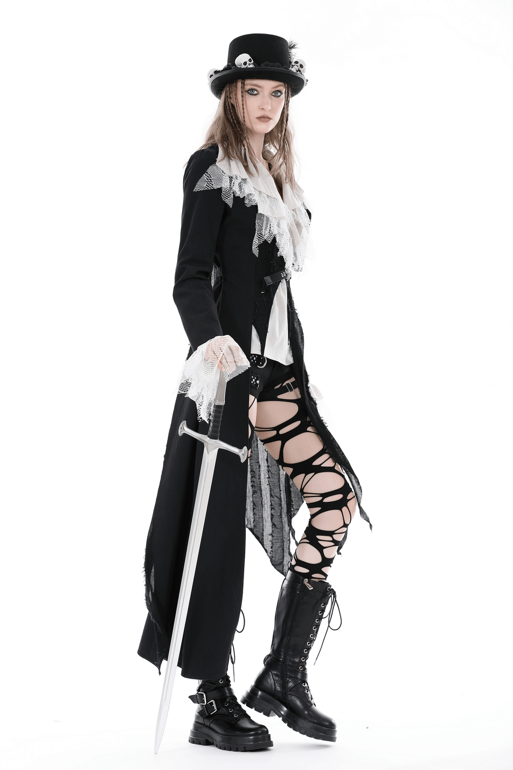 Stylish model in a long black coat with lace, wielding a sword, embodying edgy gothic fashion.