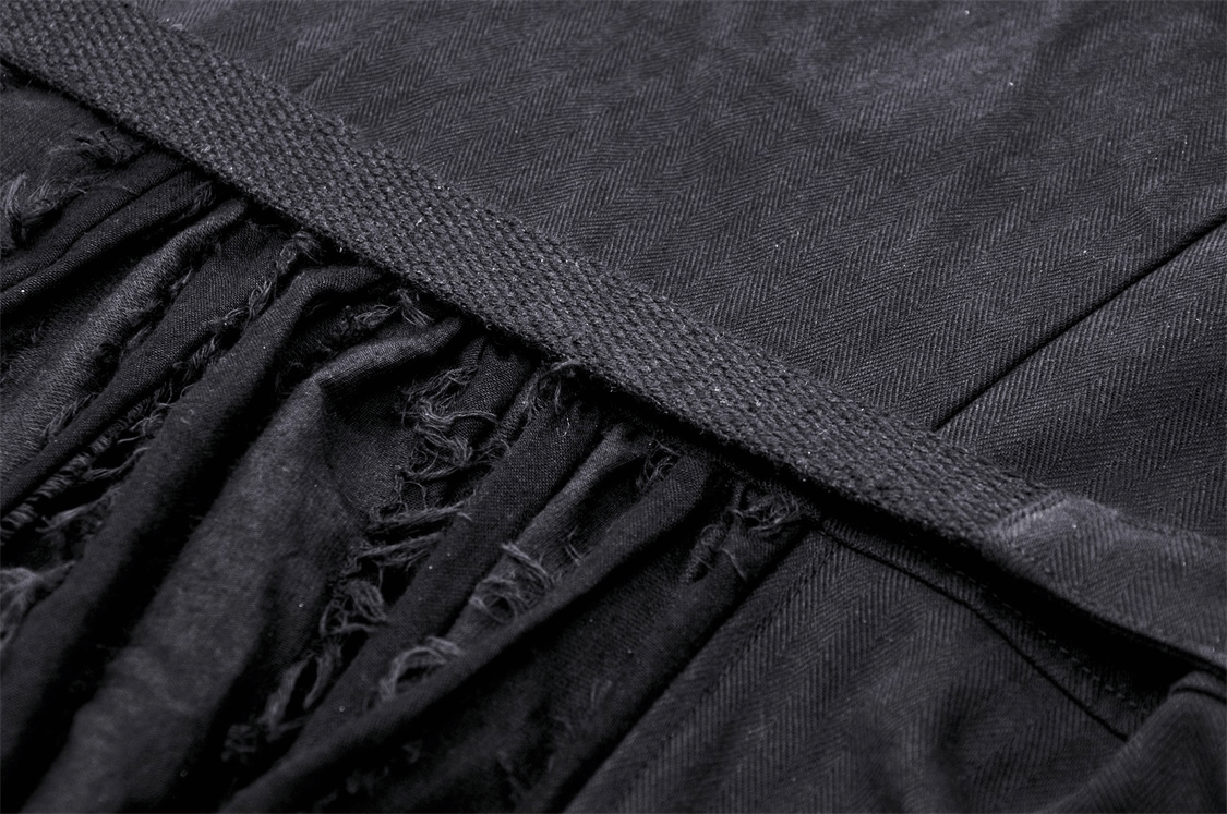 Close-up of the stylish belt detail on an elegant black long coat with a textured finish.