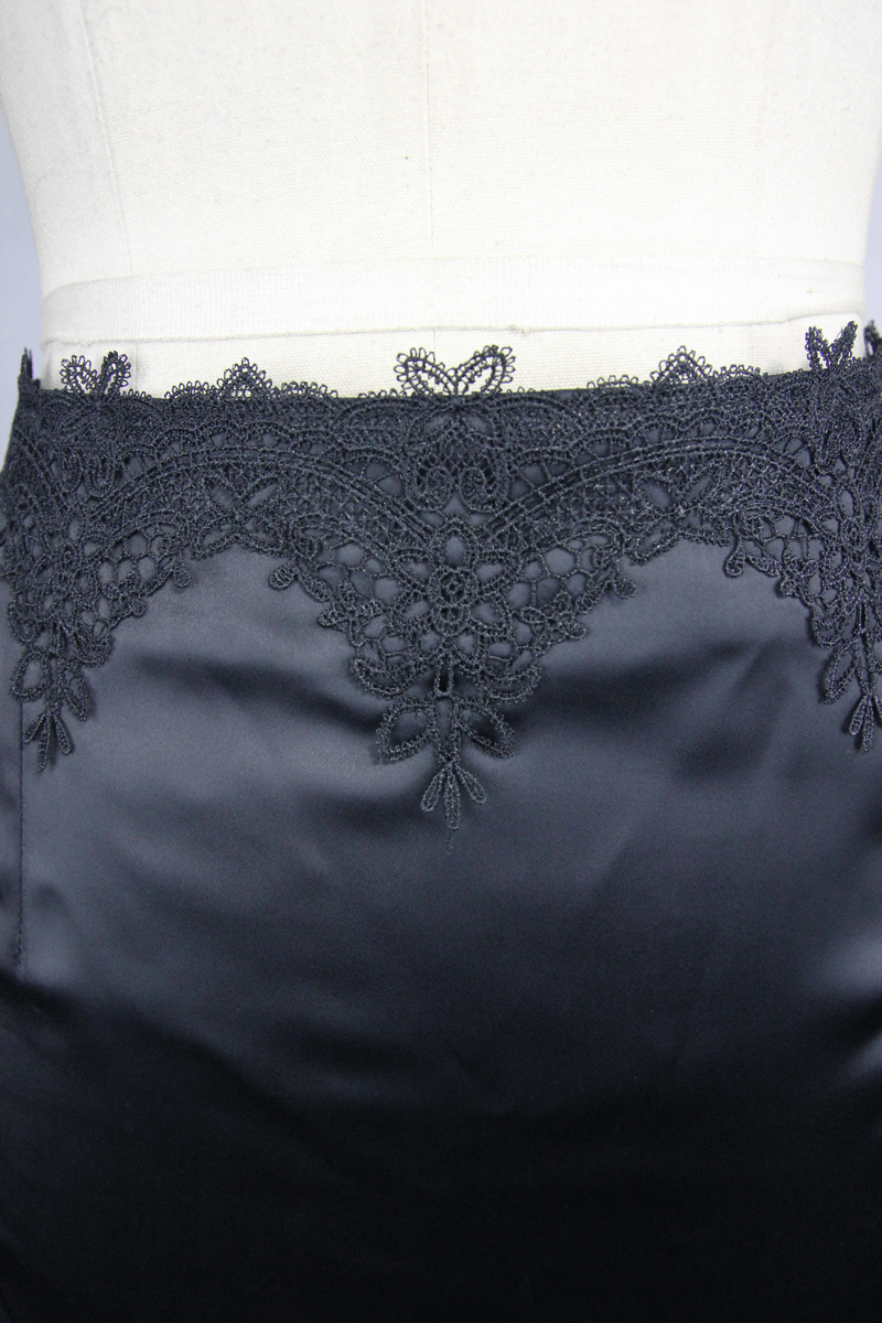 Close-up of elegant black skirt featuring intricate lace detailing along the waistband, perfect for gothic style outfits.