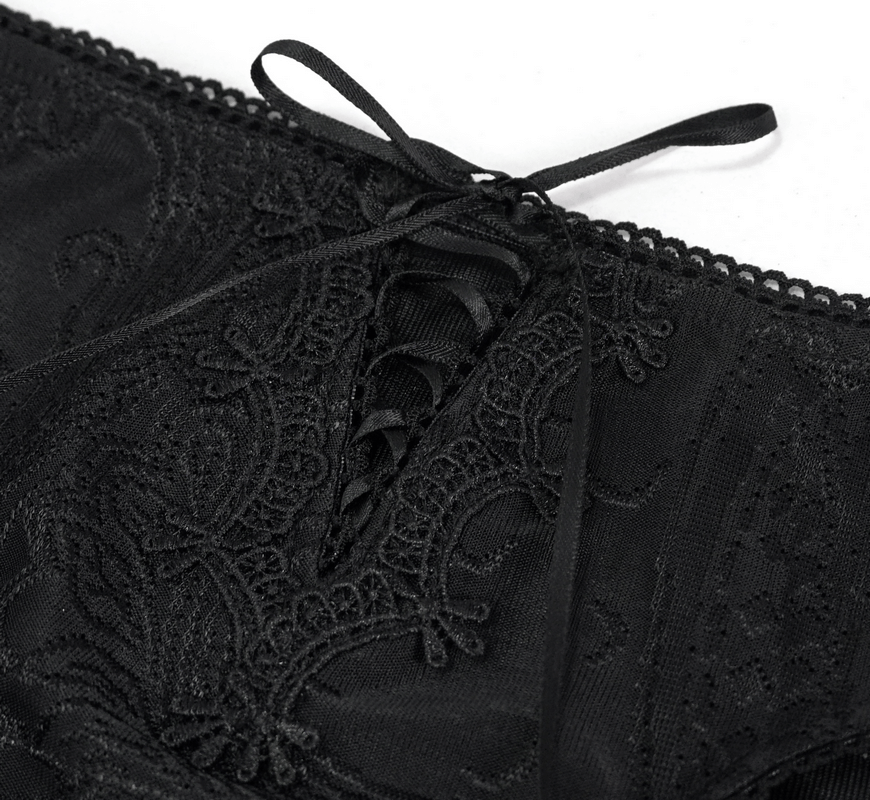 Close-up of elegant black swimsuit lace detailing with fringe and lacing for a gothic style look.