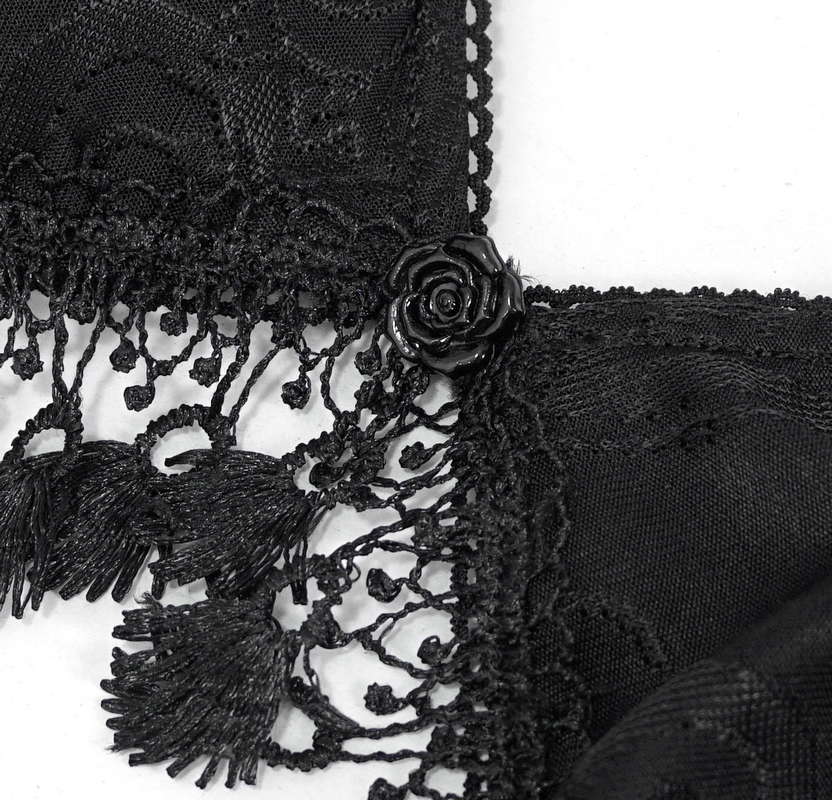Close-up of elegant black swimsuit detailing with fringed lace and rose accent, highlighting gothic style.