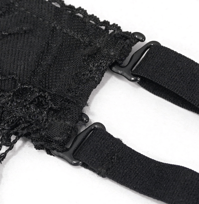 Close-up of black swimsuit fringe and strap detail, showcasing gothic style and trendy design.