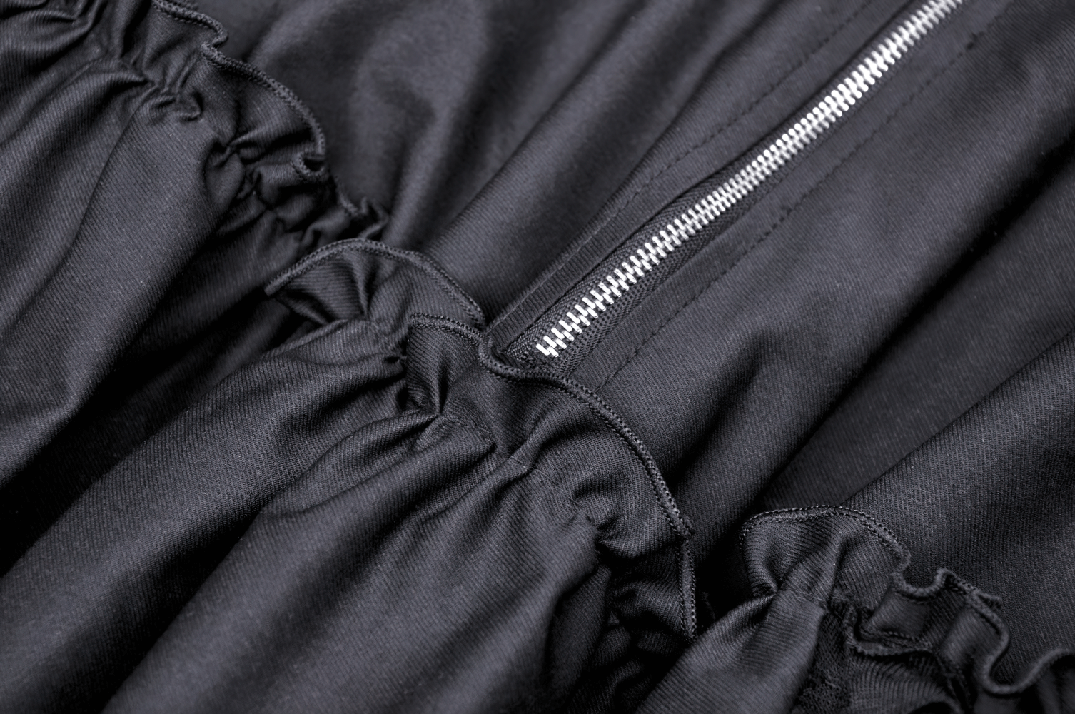 Close-up of the elegant black torn dress showing ruffled hem and zipper detail for a chic gothic look.