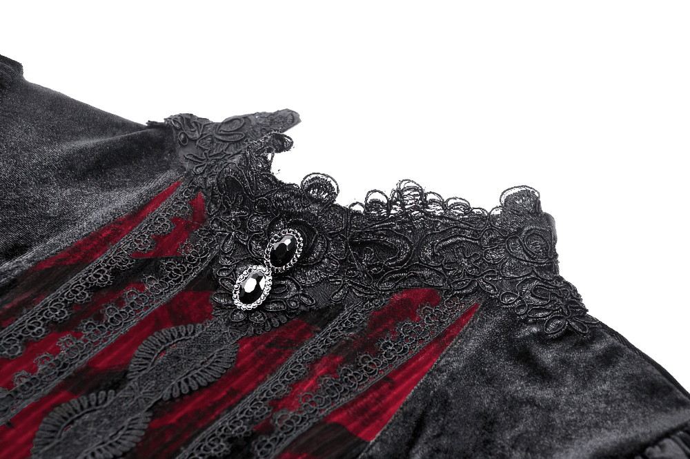 Close-up of an elegant black velvet dress collar with intricate red lace and gemstone accents.