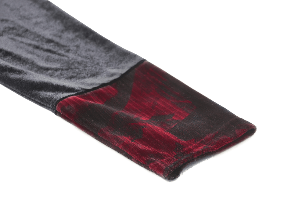 Close-up of the sleeve of an elegant black velvet dress showcasing red lace accents.
