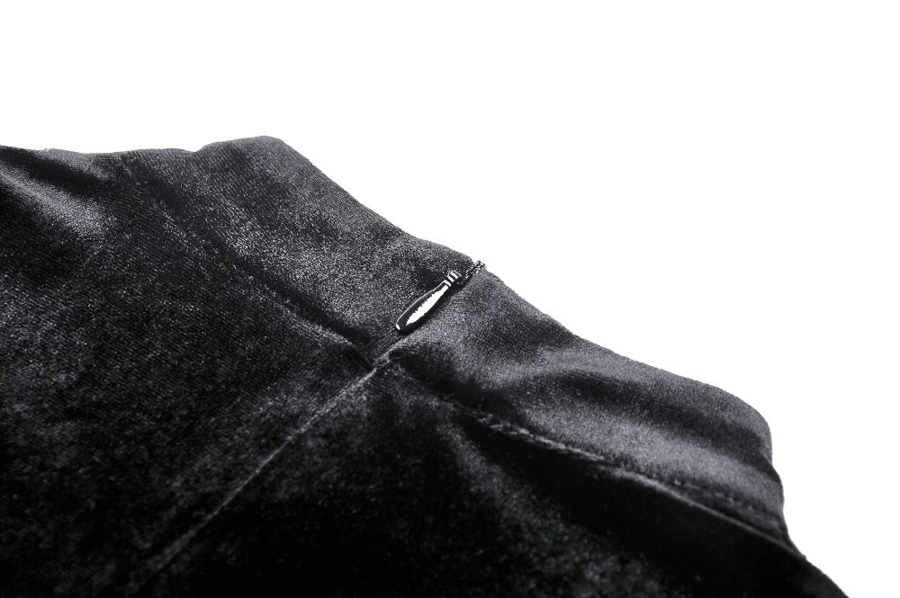 Close-up of the elegant black velvet fabric and zipper detail on a gothic dress with red lace accents.