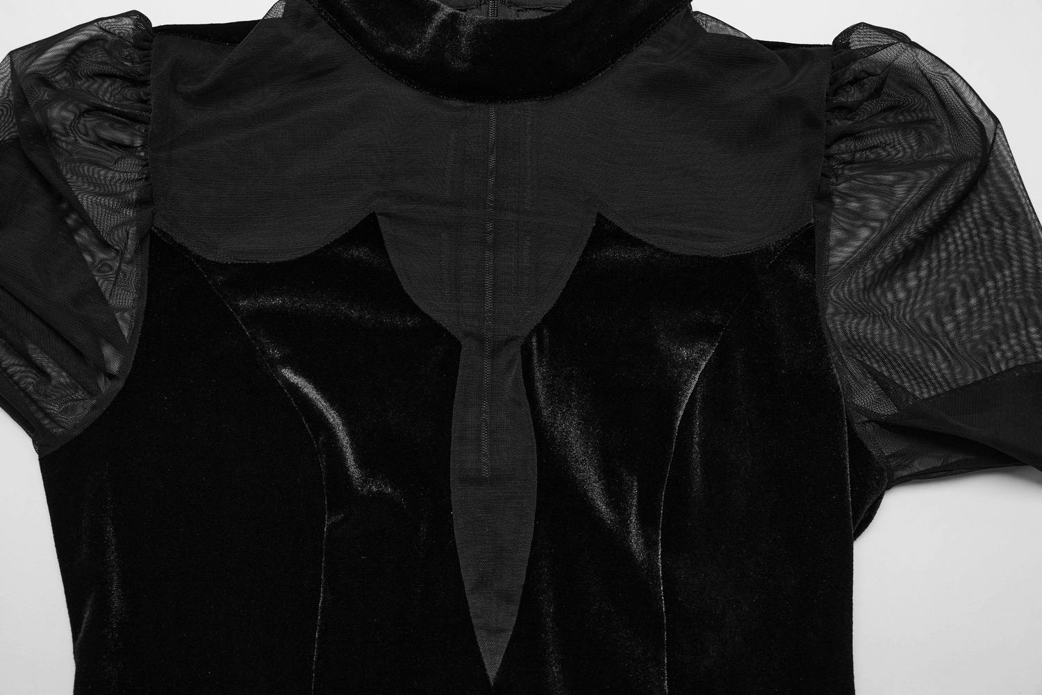 Close-up of the elegant black velvet mesh dress showcasing sheer sleeves and a striking bodice silhouette.