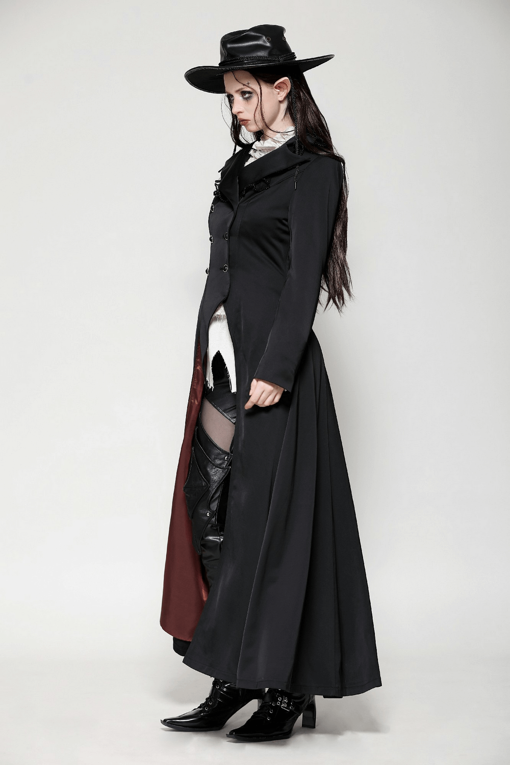 Elegant black Victorian-inspired coat with satin details, showcased by model in steampunk style attire.