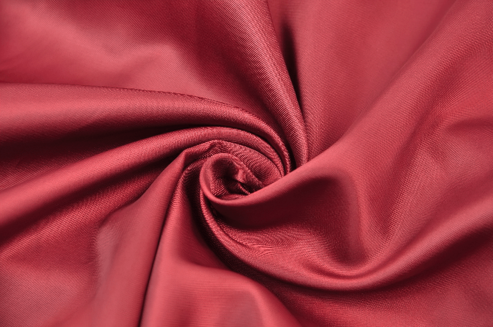 close-up of luxurious deep red satin fabric, perfect for elegant Victorian-inspired designs and steampunk attire.