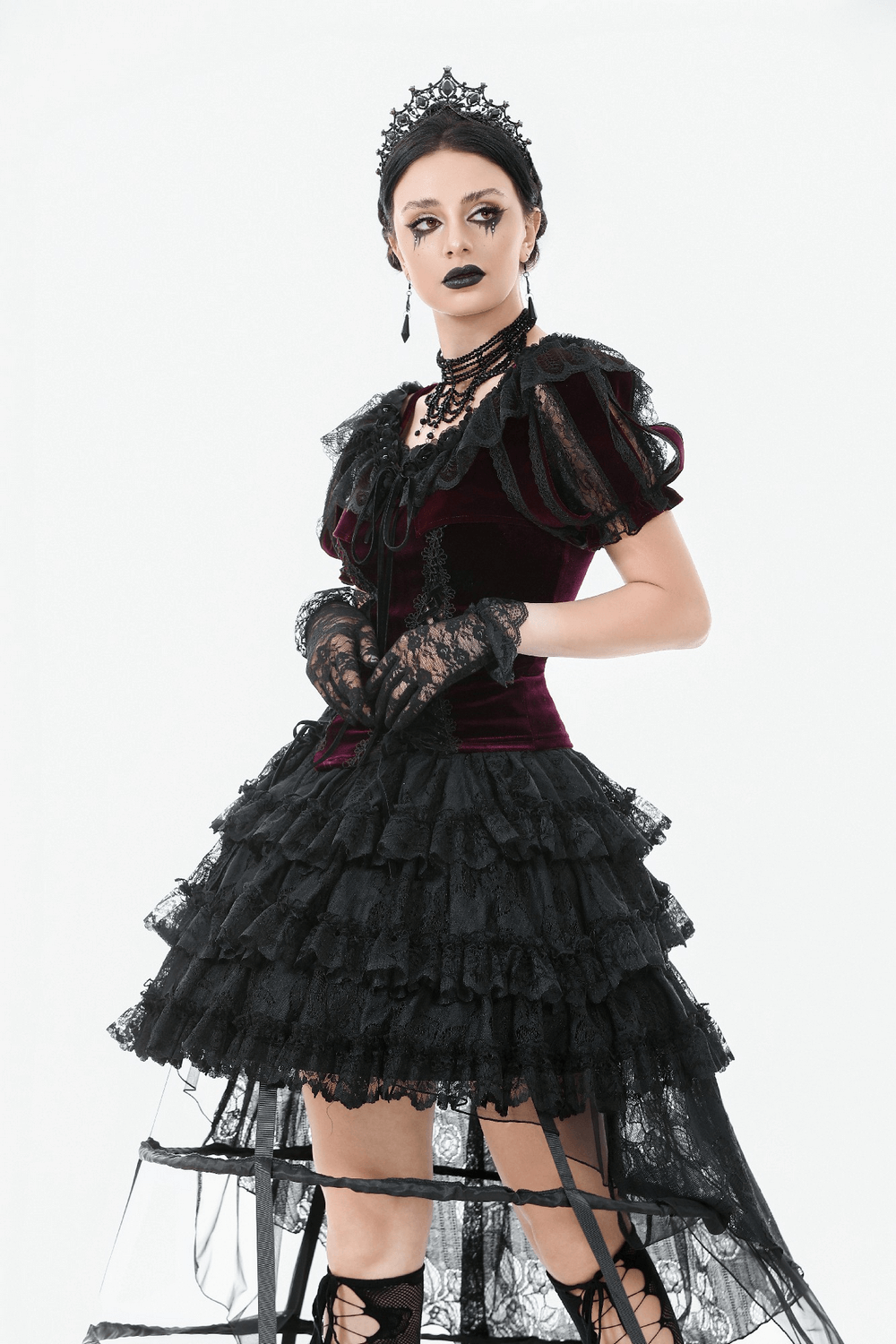 Gothic model in burgundy Victorian bolero with black lace ruffles and dramatic sleeves, showcasing dark romantic fashion.