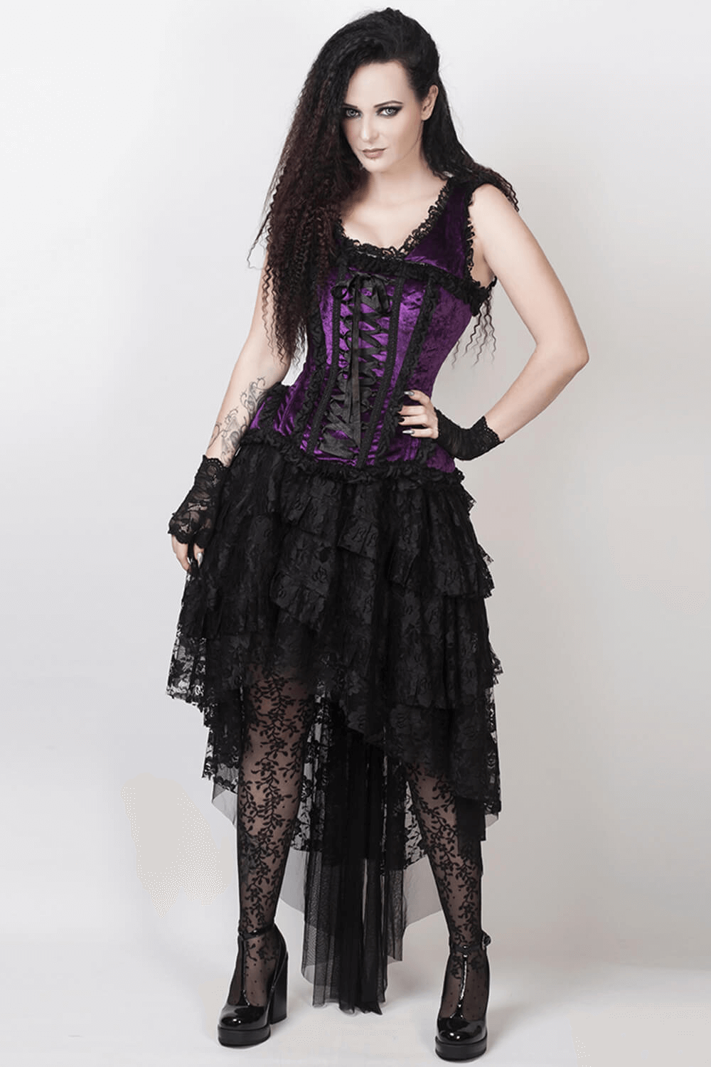 Elegant burlesque model in purple corset and layered lace skirt, showcasing a daring and stylish look.