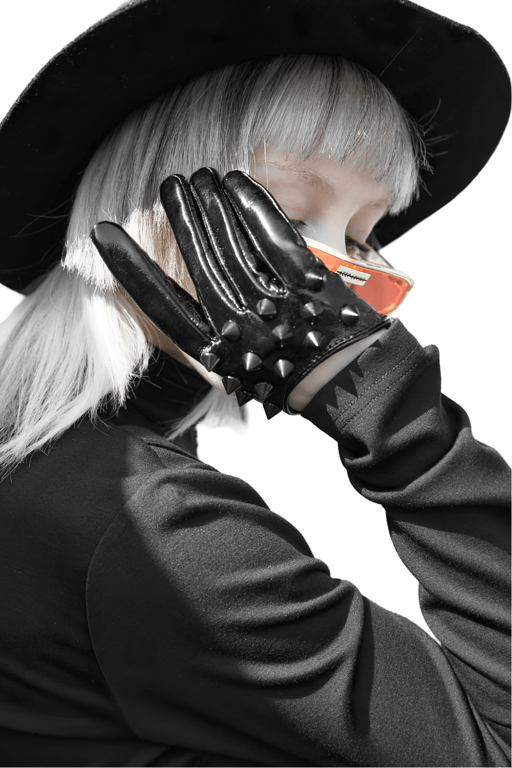 Edgy chic model wearing black spiked punk half-finger gloves and a hat, showcasing stylish rivet detail.