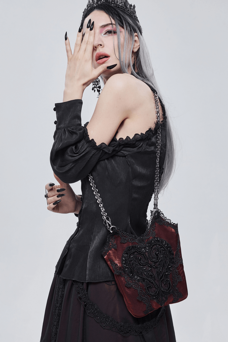 Elegant gothic woman wearing a red floral bucket bag with black guipure and chain, styled with dark fashion.