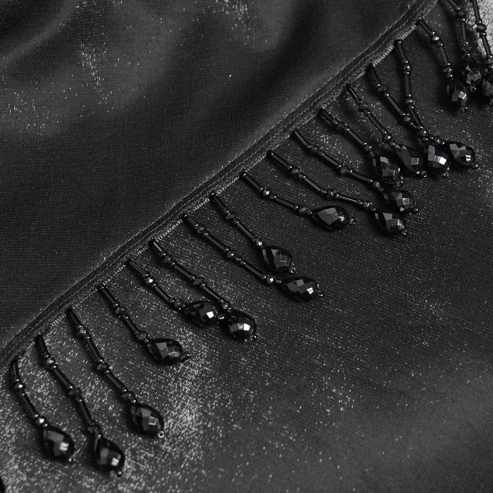 Close-up of black beaded trim with intricate details and fringe design, showcasing elegance and gothic allure.