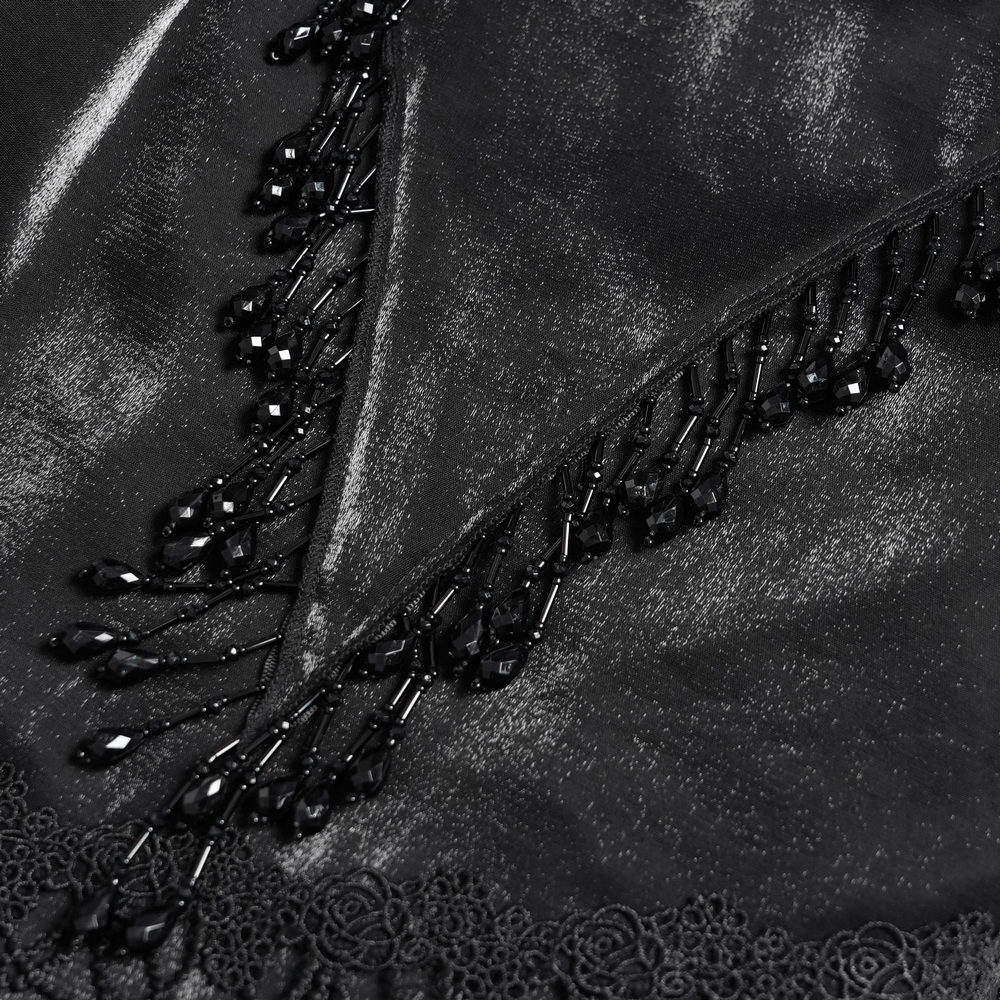 Close-up of intricate black lace with beaded trim, showcasing elegant detailing and dramatic gothic style.