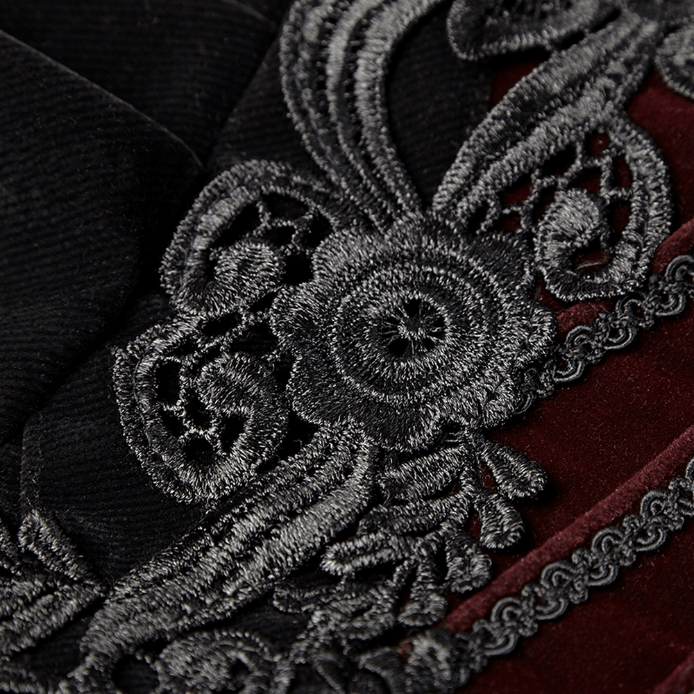 Close-up of intricate black embroidery on luxurious velvet fabric, showcasing gothic elegance and detail.