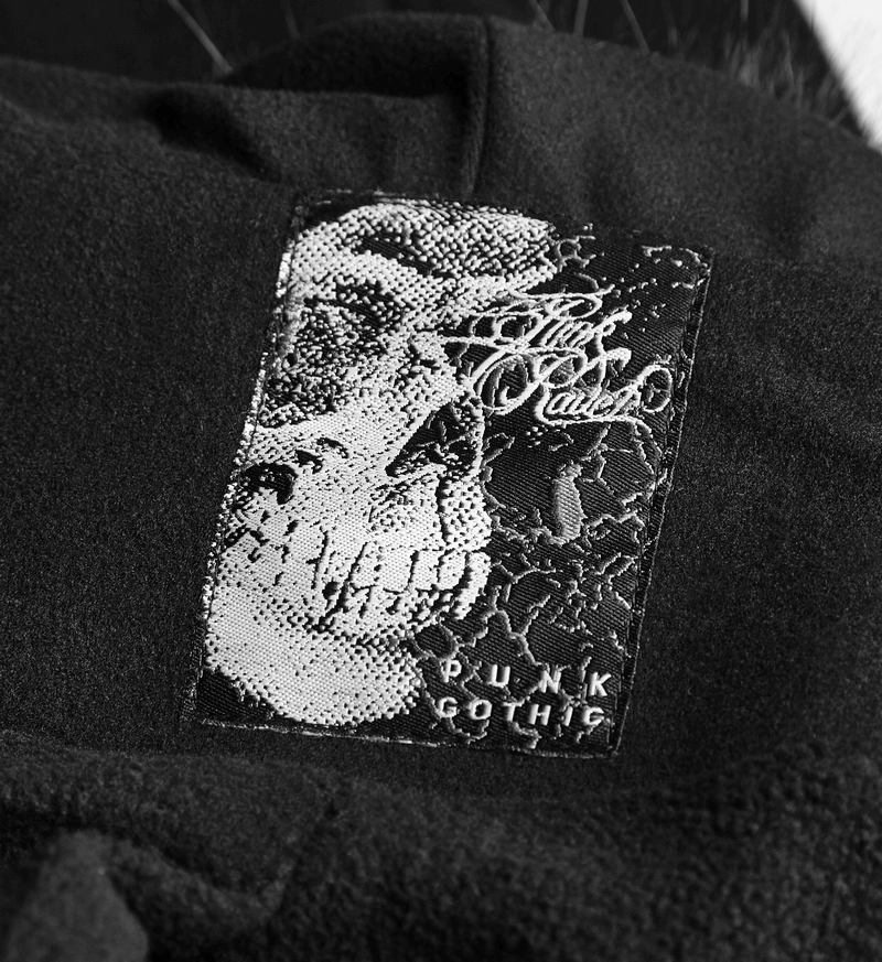 Close-up of a punk gothic label featuring a skull design on a black fabric background.