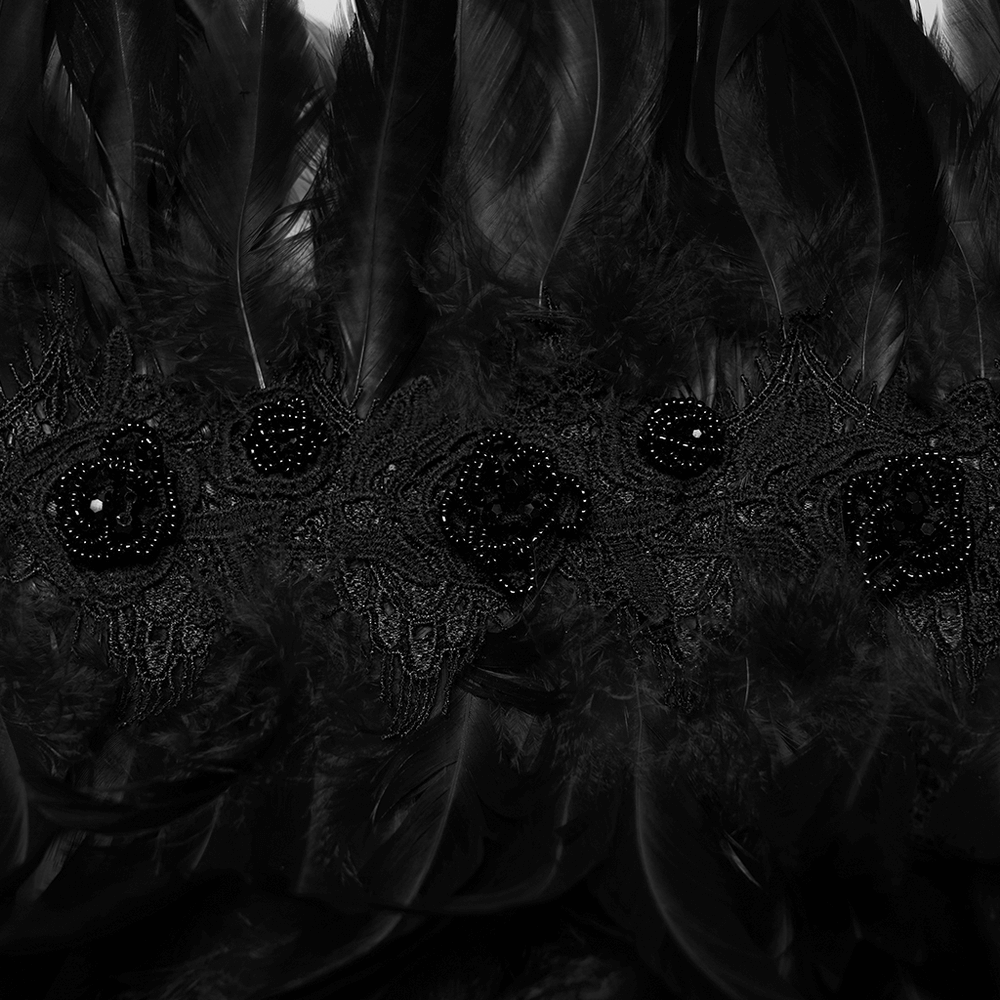 Close-up of dark feather shoulder collar featuring intricate beading and layered plumage for gothic festival wear.