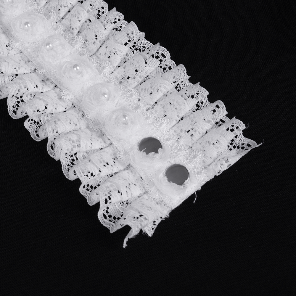 Close-up of elegant white lace ruffle detail with pearl accents on a stylish dress.