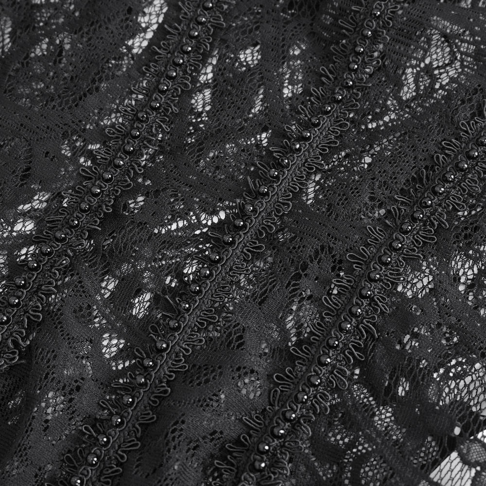 Close-up of intricate black lace fabric with fringe detailing and beads, perfect for elegant evening wear.