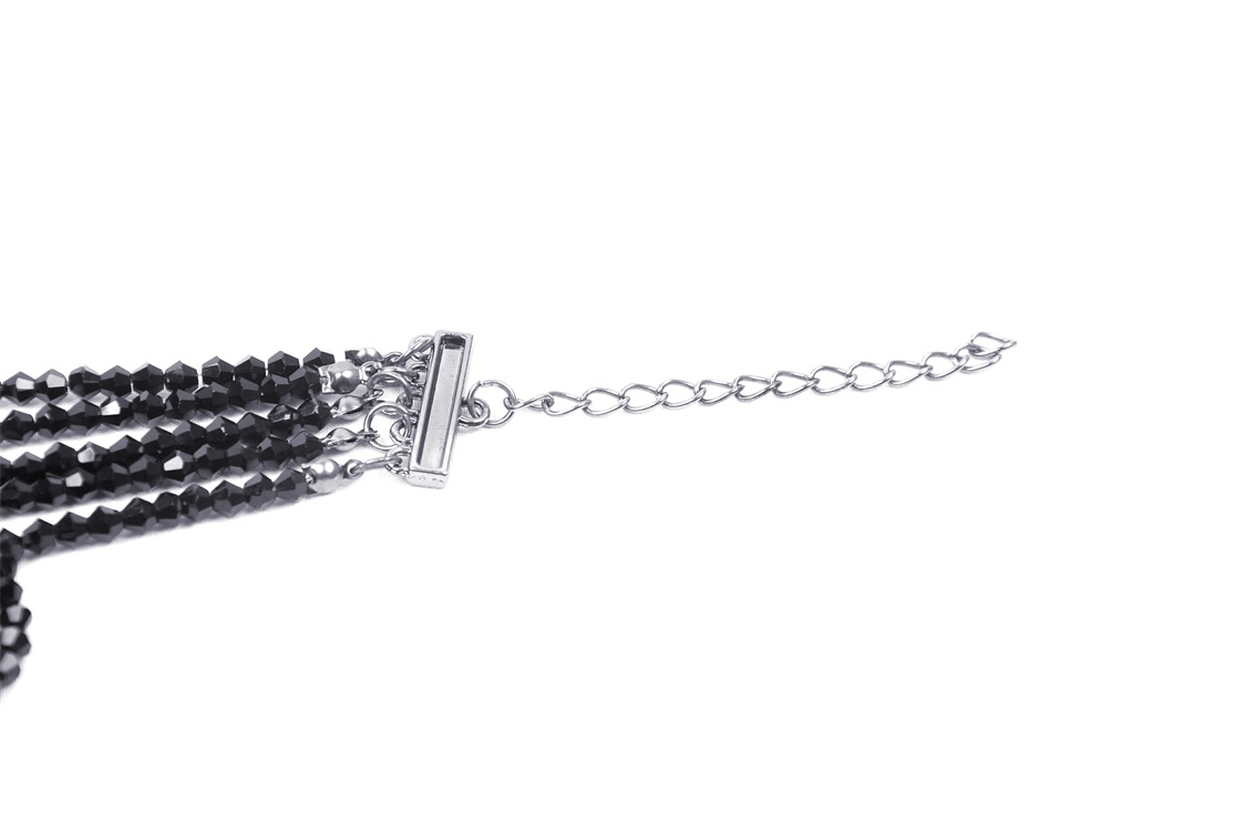 Close-up of a black beaded necklace with shiny clasp, showcasing elegant beadwork for evening glamour.