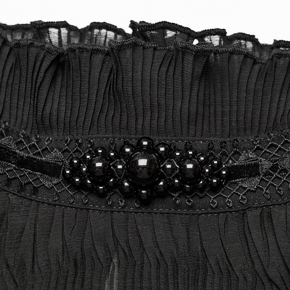 Close-up of delicate black lace and beaded detail on a goth shirt, showcasing textured ruffles and elegant adornments.