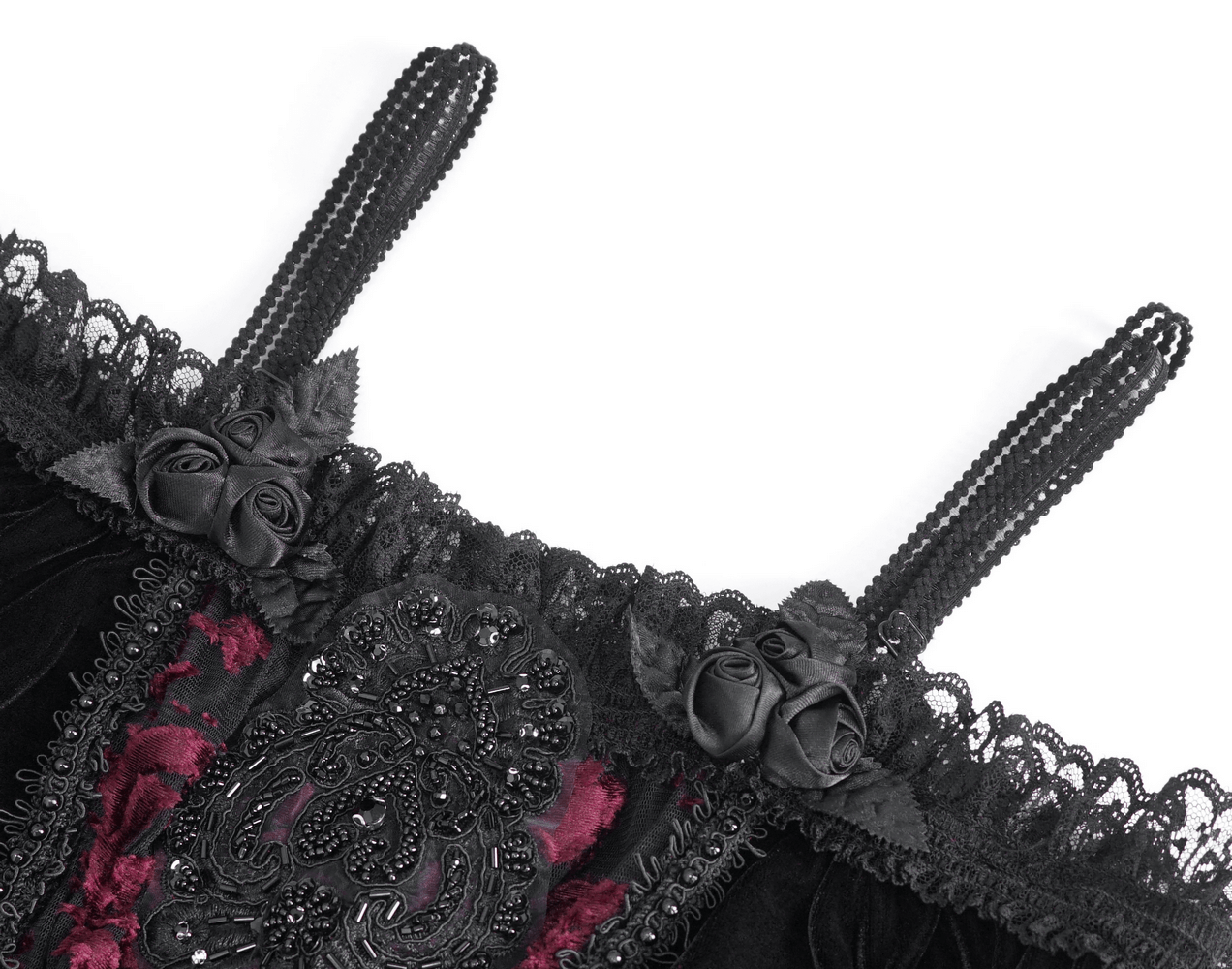 Close-up of gothic black velvet top featuring lace trim, floral embellishments, and elegant straps.