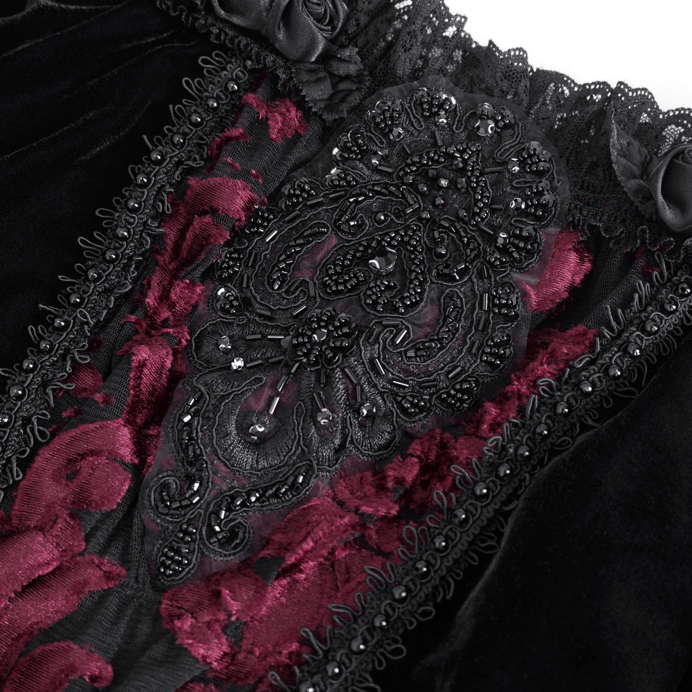 Close-up of luxurious black velvet top featuring intricate black lace and deep burgundy floral embroidery.