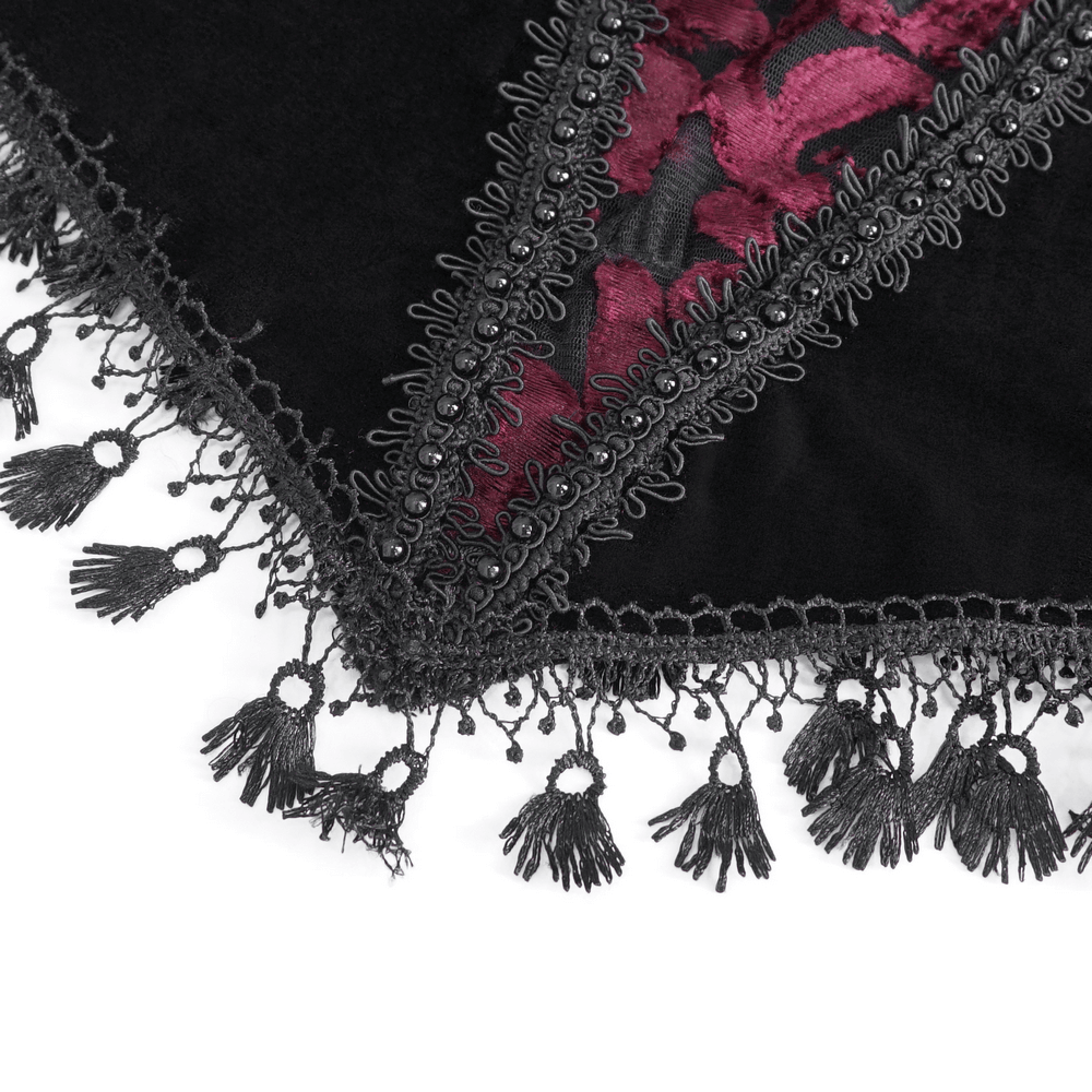 Close-up of elegant goth black velvet and lace top featuring intricate trim and tassels.