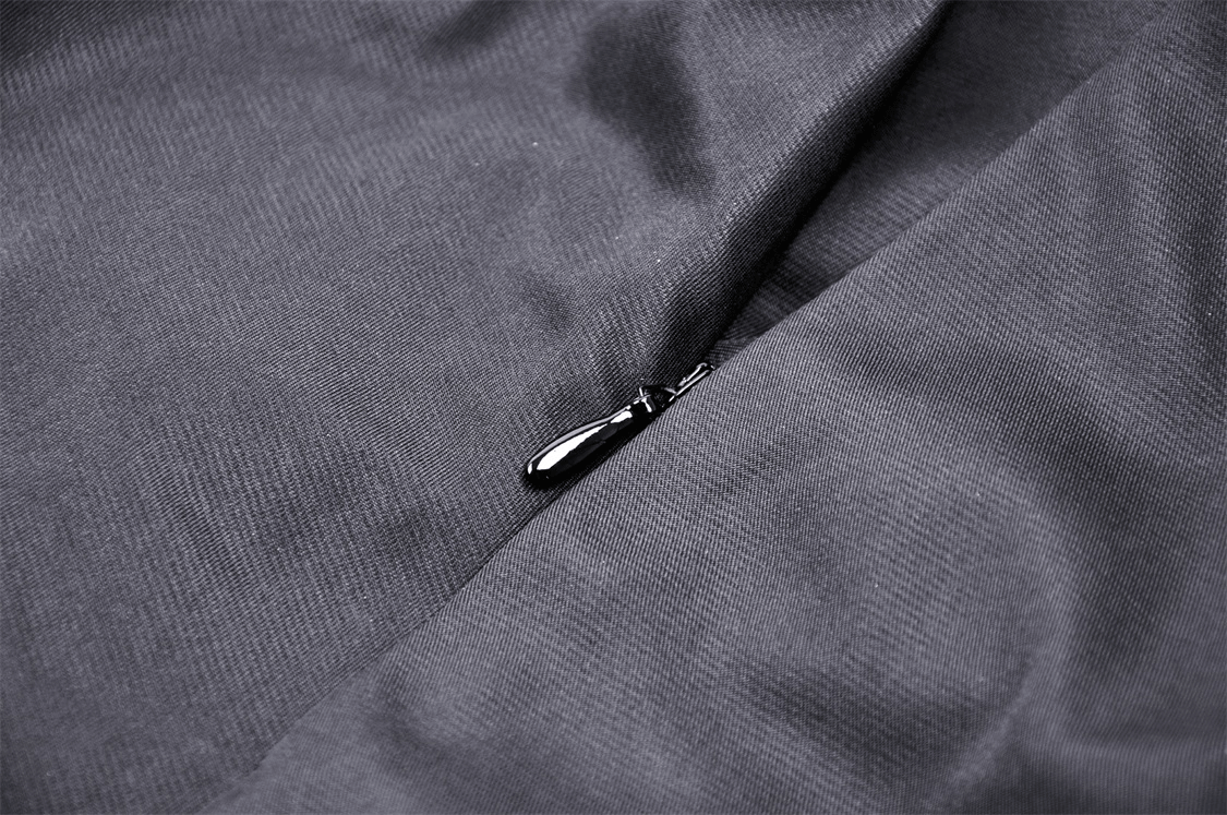Close-up of a sleek black zipper on a textured fabric, showcasing elegance and intricate detail.