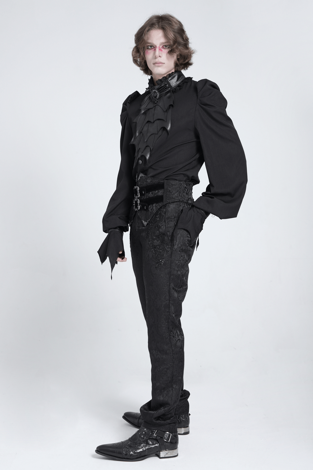 Elegant Gothic man wearing batwing layered neckwear and stylish black attire.