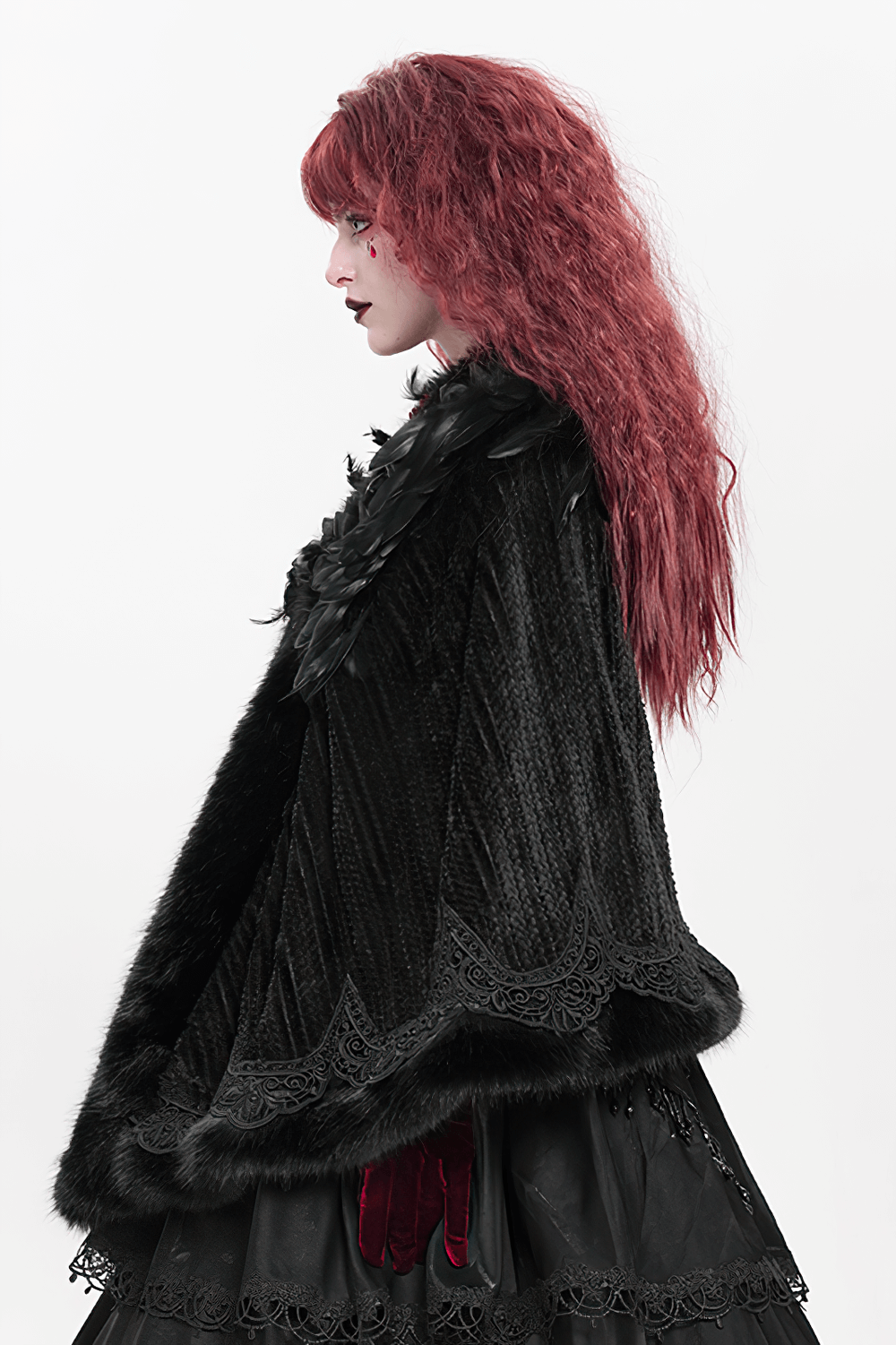 Profile view of a person in an elegant gothic black cape with feathers and lace trim, showcasing dark elegance and Victorian style.