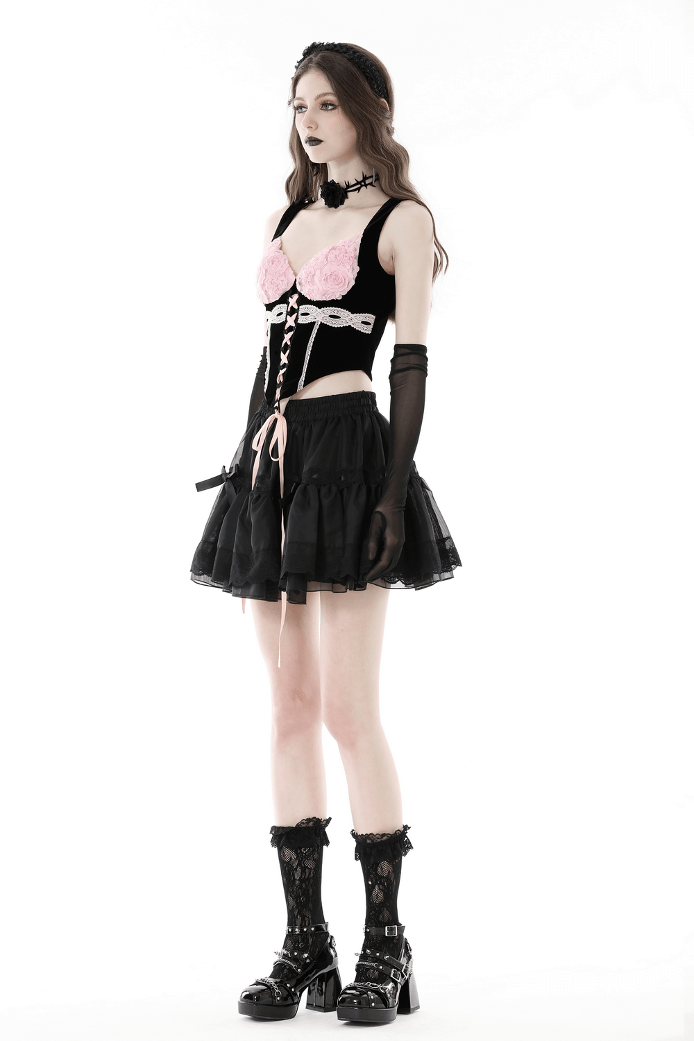 Elegant Gothic black corset top with pink lace accents, stylishly worn with a black skirt and accessories.