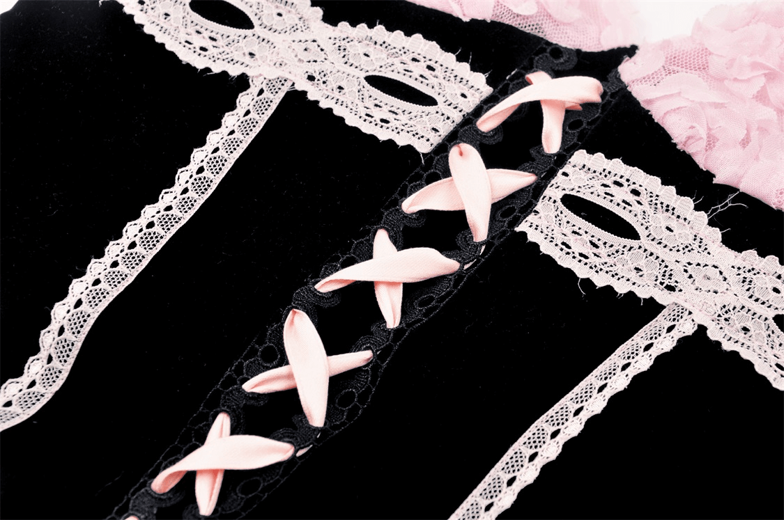 Close-up of a black corset top with pink lace accents and ribbon ties, showcasing elegant floral details.