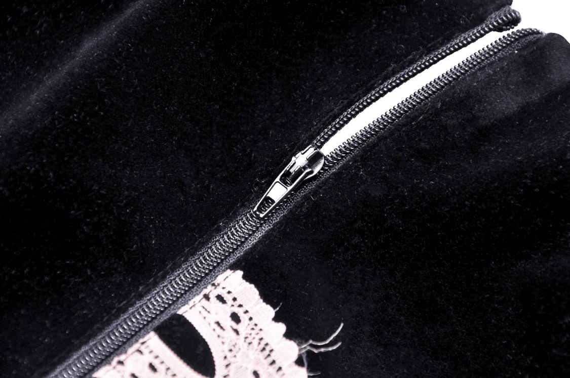Close-up of the zipper detail on an elegant black corset top with pink lace accents, showcasing its chic design.