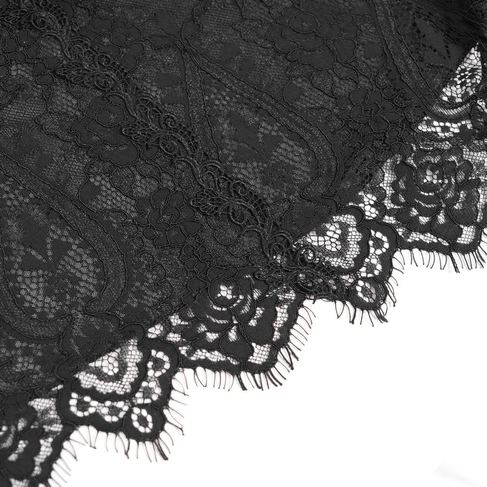 Close-up of elegant black lace fabric showcasing intricate floral patterns and delicate fringed edges.