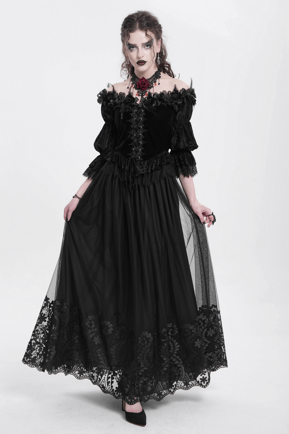 Elegant gothic woman in black mesh maxi skirt with ornate embroidery, showcasing a dramatic dark romantic style.