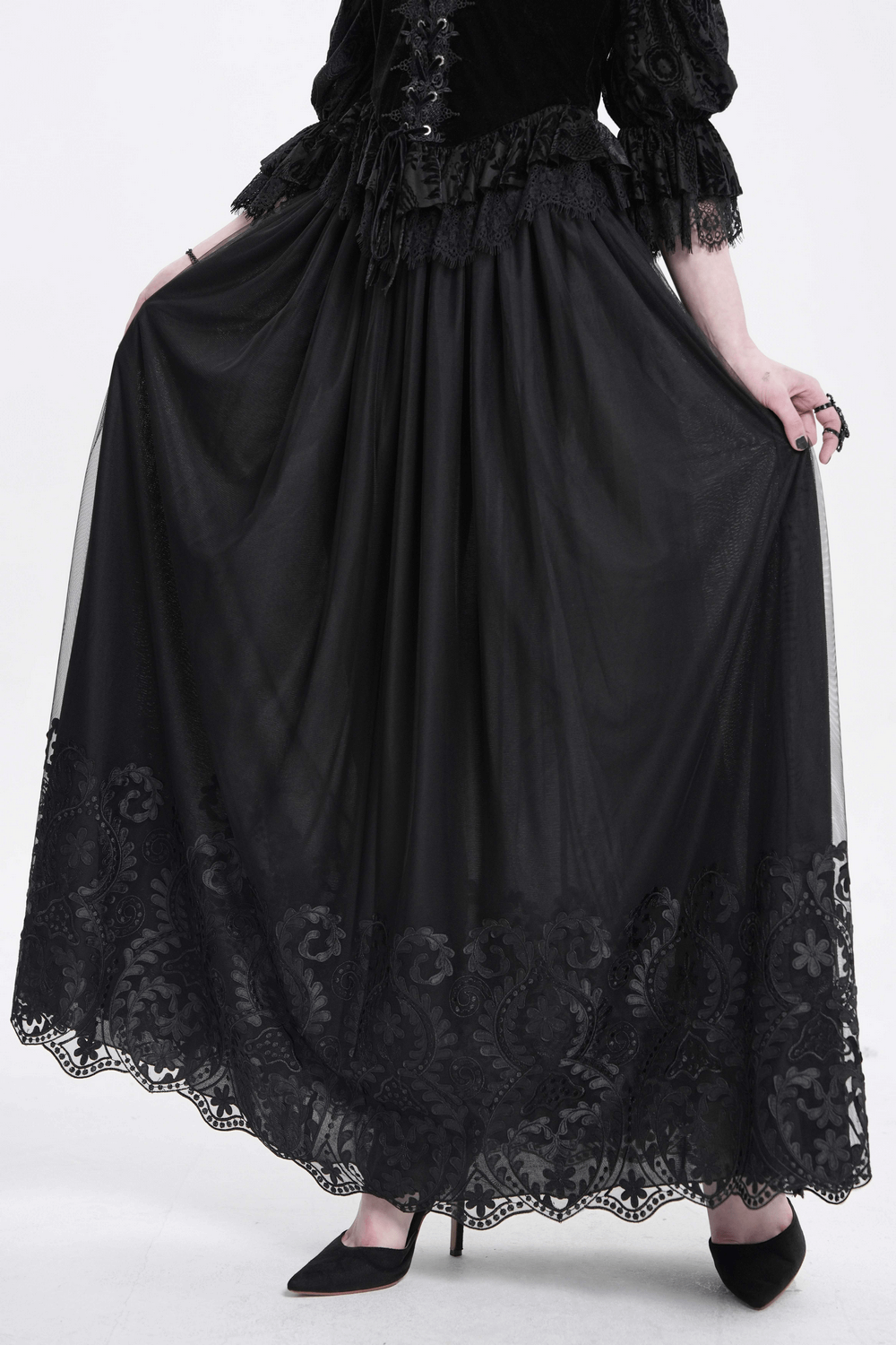 Elegant black mesh maxi skirt with embroidered floral hem, ideal for gothic and alternative fashion.