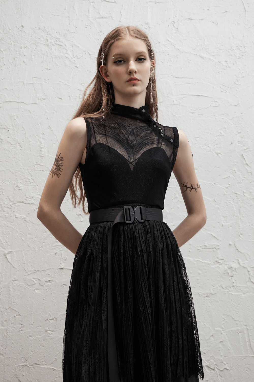 Edgy black mesh sleeveless top with high neck and slant placket, paired with a belt for a punk rock look.