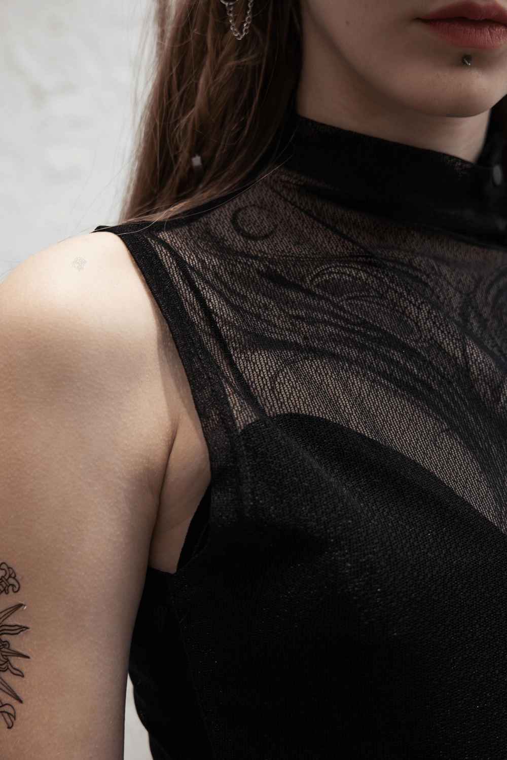 Close-up of a woman wearing an elegant gothic black mesh top with high neck and intricate design.