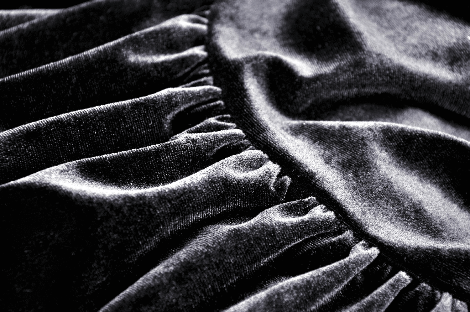 Close-up of luxurious black velvet fabric, showcasing texture and softness for gothic fashion enthusiasts.