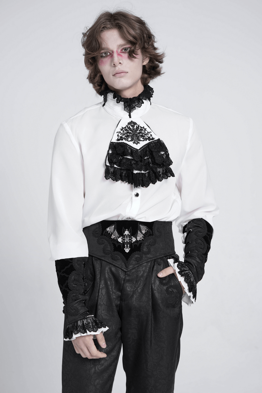 Young model in gothic attire featuring a ruffled shirt and lace details, perfect for a dark romantic look.