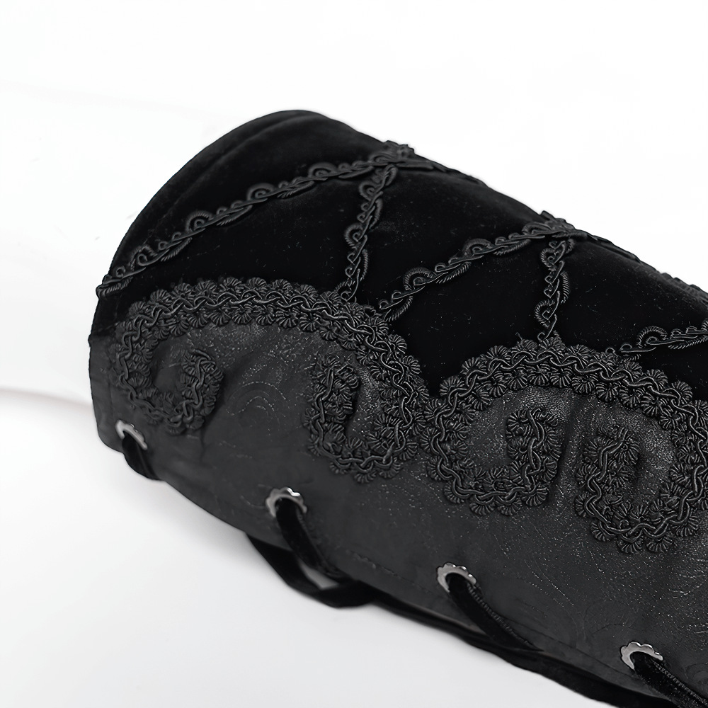 Close-up of an elegant black velvet arm bracelet with baroque embroidery and adjustable lace-up detail.