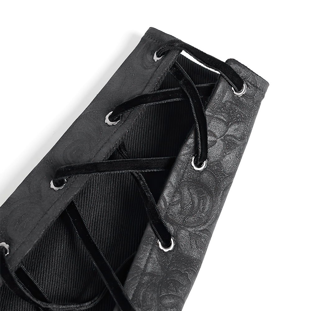 Close-up of elegant black velvet arm warmer featuring intricate lace-up design and baroque embroidery.