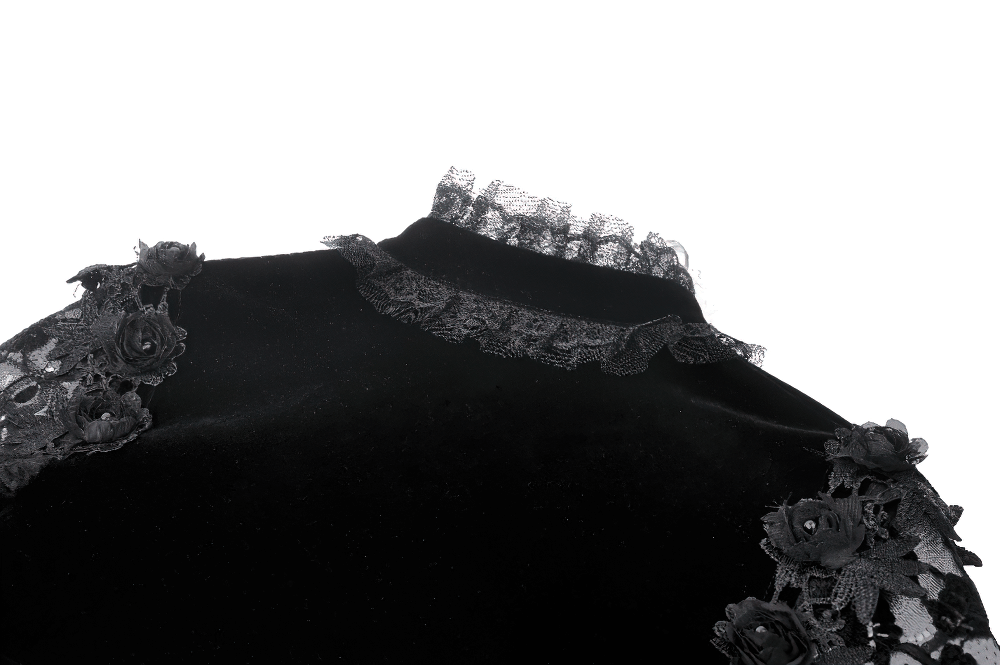 Close-up of an elegant black velvet bolero with lace trim and floral details, showcasing gothic fashion style.
