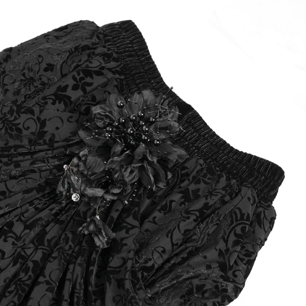 Close-up of elegant black velvet skirt featuring floral embroidery and beaded accents, ideal for gothic fashion.